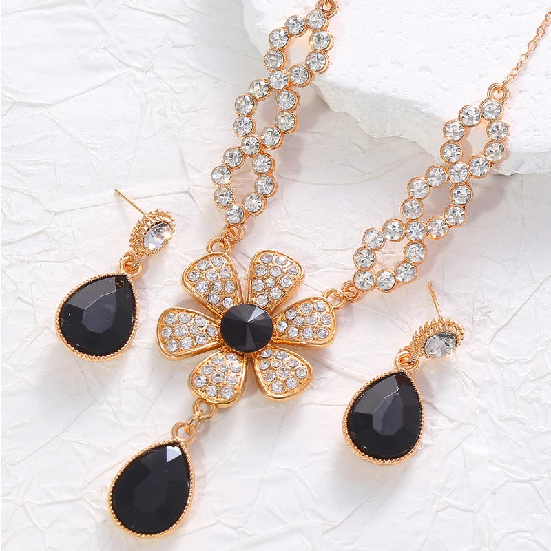 The two-piece set featuring flower elements with rhinestone inlays, earrings and necklace, highlights elegant charm.