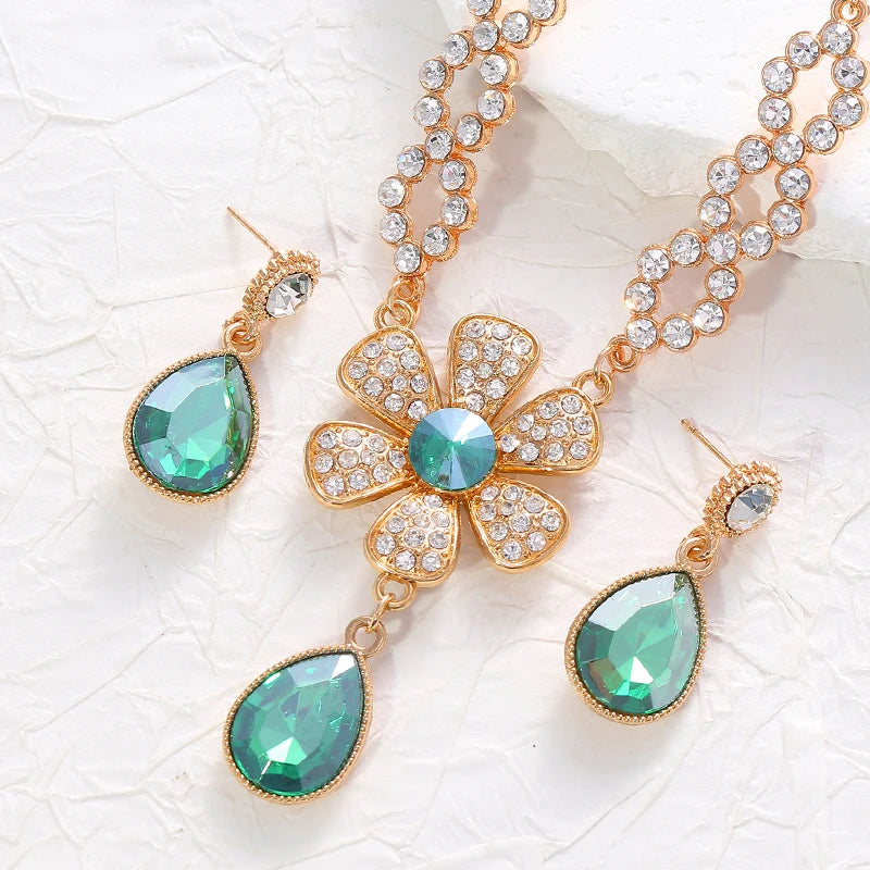 The two-piece set featuring flower elements with rhinestone inlays, earrings and necklace, highlights elegant charm.
